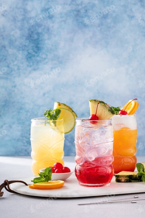 Preview: Variety of tropical tiki cocktails with cold foam, garnished with orange slices, cherry and mint