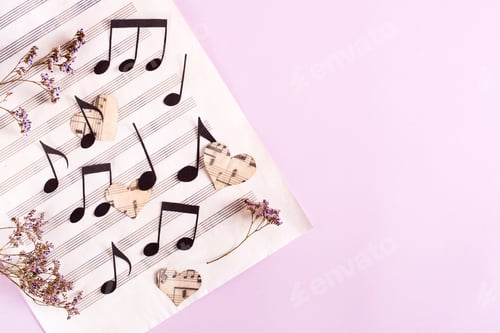 Visualização: O conceito de amor pela música. Notas de papel e corações em uma partitura musical. Vista superior