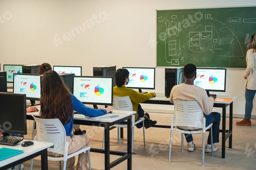 Preview: Multiracial students using computers during business class wearing protective masks at school