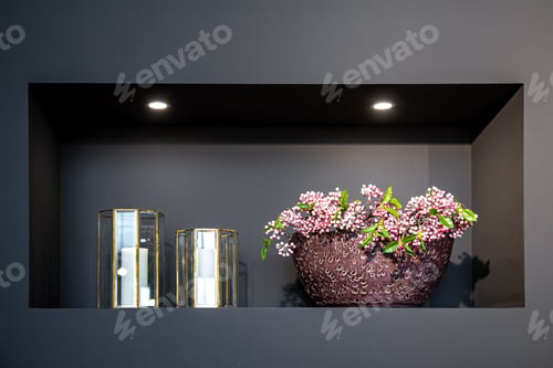 Preview: Closeup, vase with flowers and glass candlesticks in home interior.