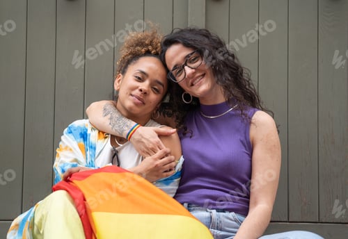 Preview: Multiethnic women couple hugging while sitting isolated no green background