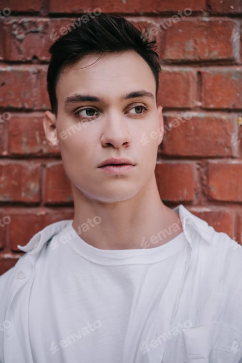 Preview: portrait of handsome young man looking away on street