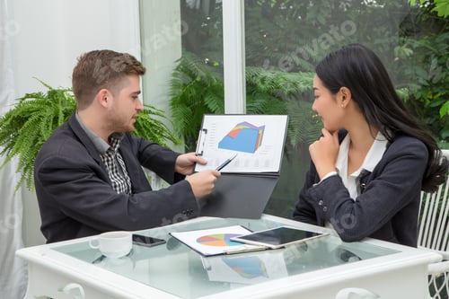 Preview: Young successful business couple is talking and viewing documents