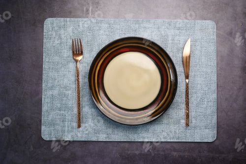 Preview: cutlery and empty plate on wooden background top down
