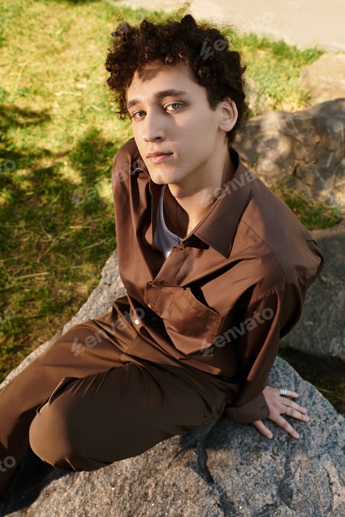 Preview: Young man enjoying a stylish summer day in a lush green park setting