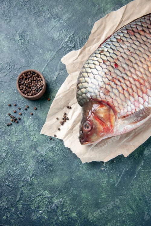 Preview: top view fresh raw fish with pepper on dark-blue background meat water ocean color food seafood meal