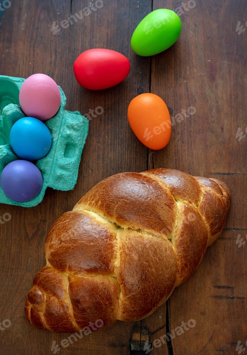 Preview: Easter eggs and tsoureki braid, greek easter sweet bread, on wooden background