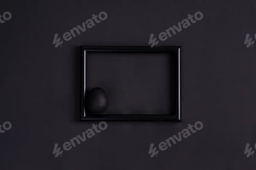 Preview: Black easter egg by paintbrash in black color on the black photo frame and black background