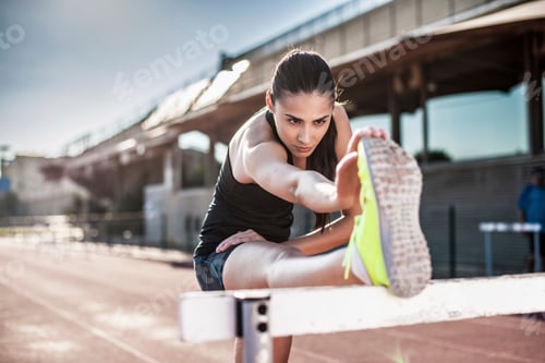 Preview: Athlete stretching before a run at the track.