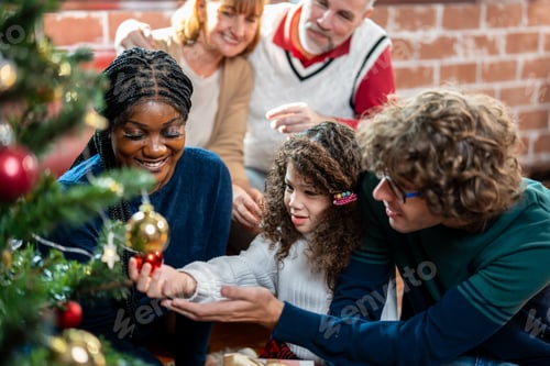 Visualização: Família caucasiana e filha pequena decorando a árvore de Natal em casa.