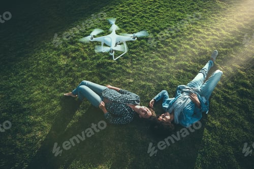 Preview: Black and Caucasian girl on the grass, flying UAV above