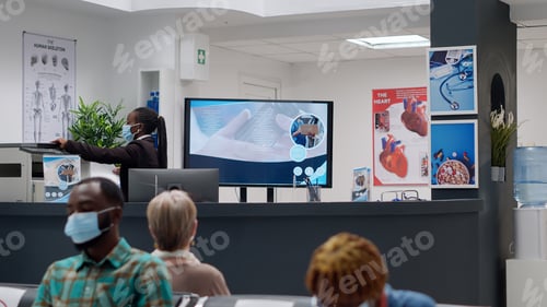 Preview: African american receptionist with face mask working on appointments