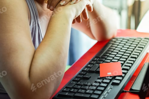 Preview: latina woman pensive with credit card on keyboard, reviewing her financial statement