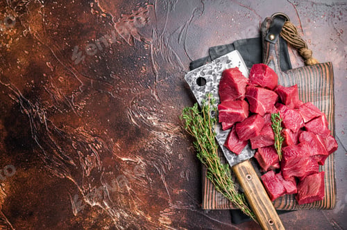Preview: Diced Raw Boar meat, uncooked Game Meat on butcher cutting board. brown background. top view