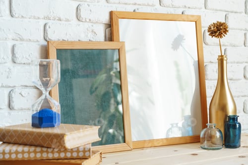 Preview: Wooden frame mockup on table with modern vase and books