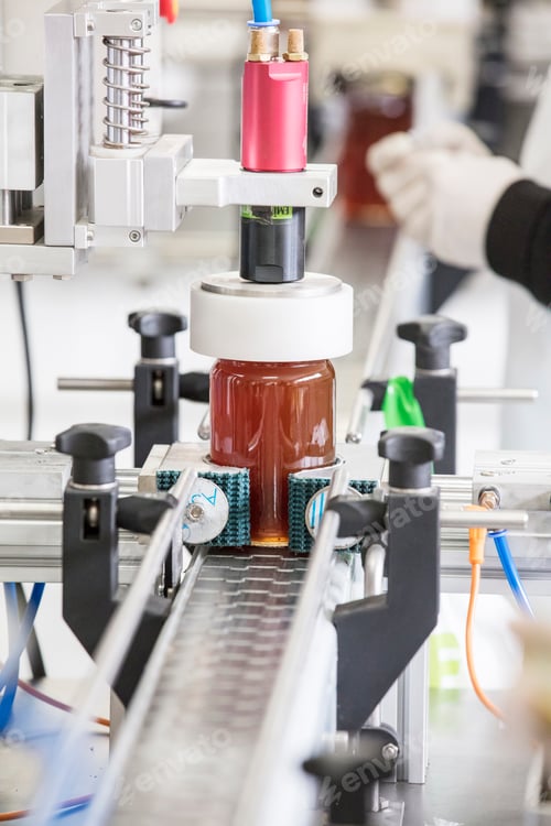 Preview: Filling empty jars with fresh honey in factory.