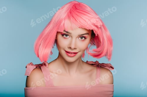 Preview: beautiful happy girl posing in pink wig isolated on blue
