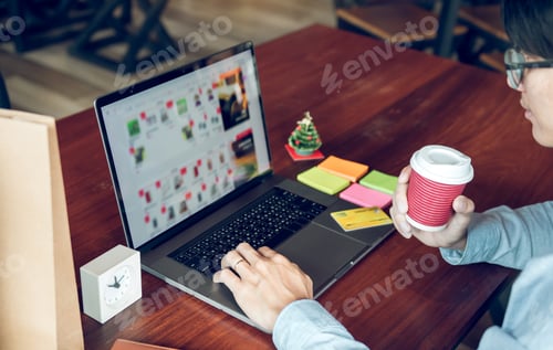 Preview: Man holding laptop and typing keyboard looking product for shopping online.
