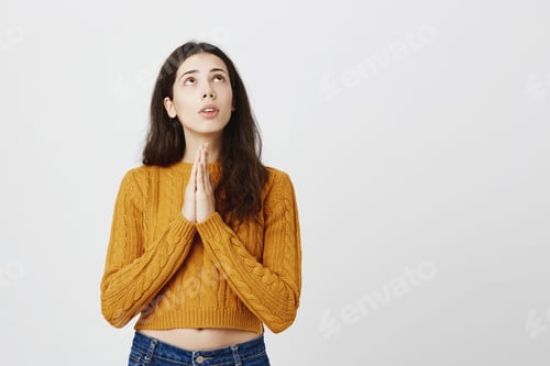 Preview: Portrait of young cute female student looking up with worried and determined expression, holding
