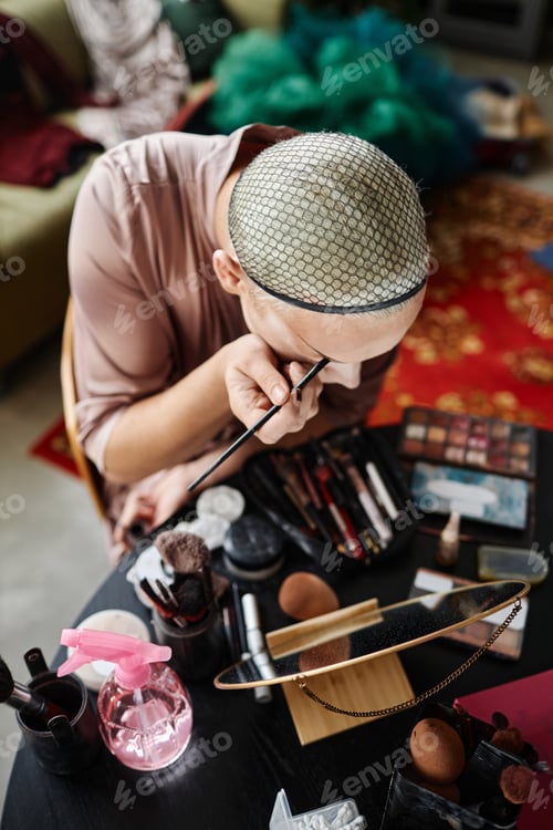 Preview: Young Doing Makeup at Cluttered Table in Dressing Room