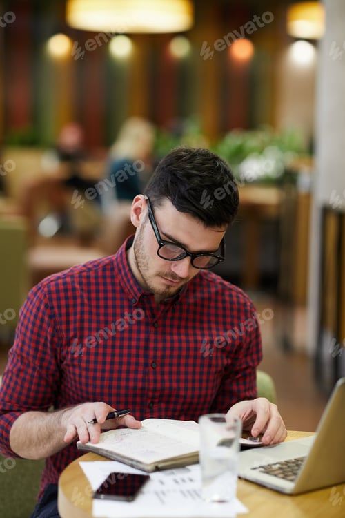 Young Adult Reading at Desk with Laptop