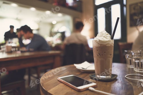 Preview: Cellphone and drinks on wooden table in coffee shop