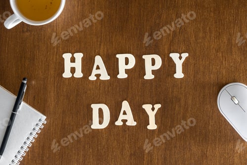Preview: Happy day, wooden letters on the office table, top view.
