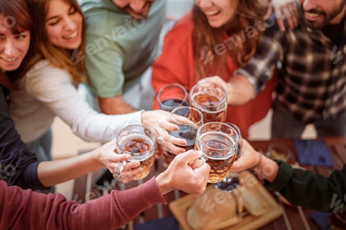 Preview: Group of friends toasting and clinking glasses of beer and wine at an outdoor celebration party.