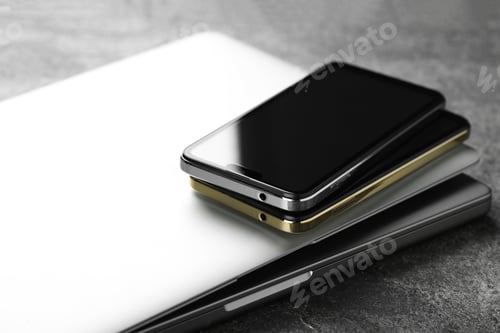 Preview: Stack of electronic devices on grey table, closeup