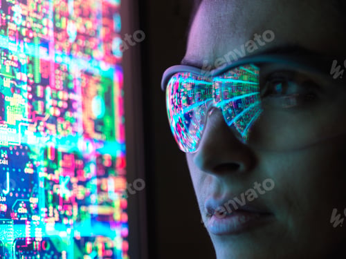 Preview: A person immersed in the digital world as vibrant circuitry reflects off their glasses.