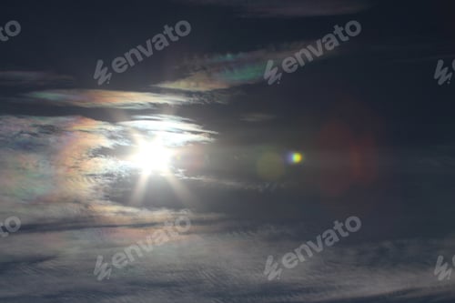 Preview: Brilliantly Colored Iridescent Clouds In A Blue Sunny Sky - Photograph Of A Bright Sun Surrounded