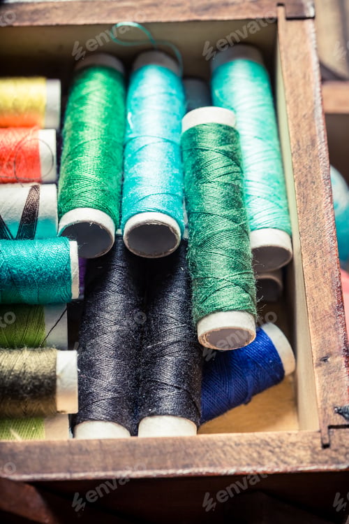 Preview: Closeup of tailor's wooden box with buttons, threads and needles