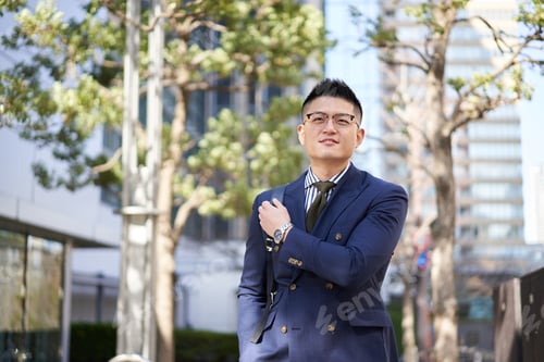 Preview: Asian businessman walking with a backpack on his back