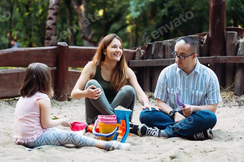 Preview: Happy family spending fun time together playing in sand