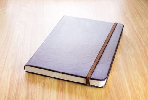 Preview: Brown Hard cover notebook with elastic strap on wooden table