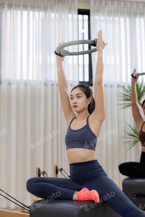 Preview: Young woman training pilates with magic circle