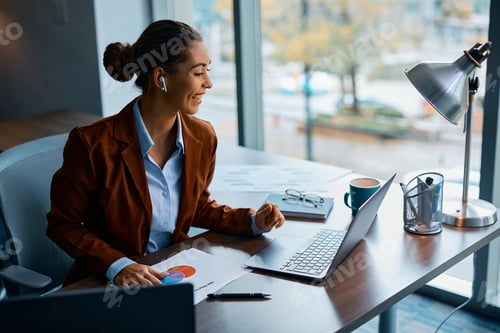 Preview: Happy businesswoman having video call over laptop while working in the office.