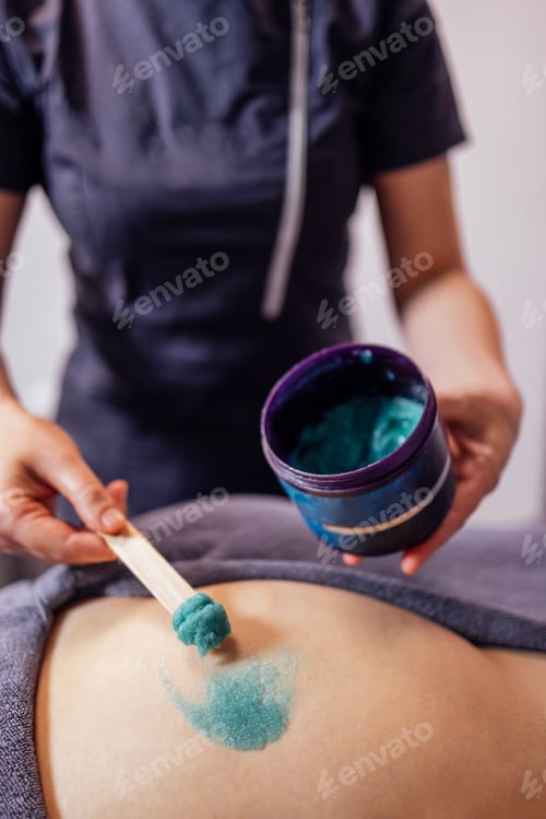 Preview: Close-up of the cosmetologist hands and a jar of salt scrub