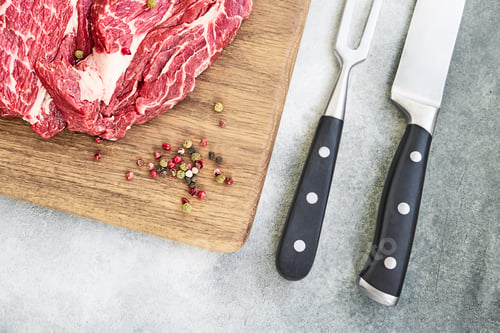 Preview: Fresh raw beef steaks with pepper on wooden cutting board board. Copy space, top view.
