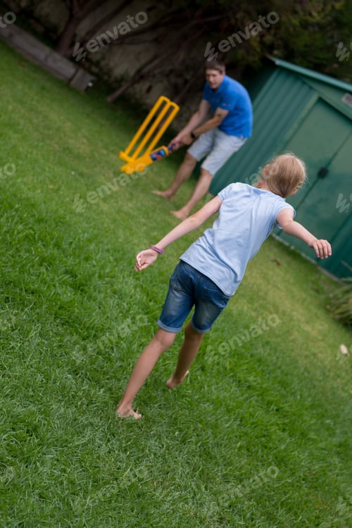 Preview: Father and daughter enjoy backyard cricket. Family fun