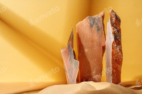 Preview: Marble rocks in sand against yellow background