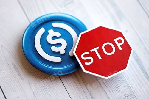 Preview: USDC stable coin and red paper stop sign on wooden background