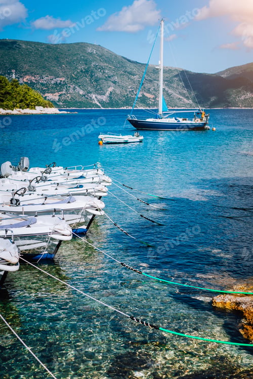 Preview: Small tourist boats for rent docked on the shore. Turquoise bay, crystal clear water. Amazing summer