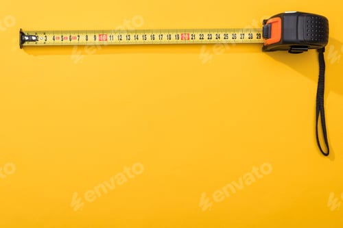 Preview: Top view of industrial measuring tape on yellow background with copy space