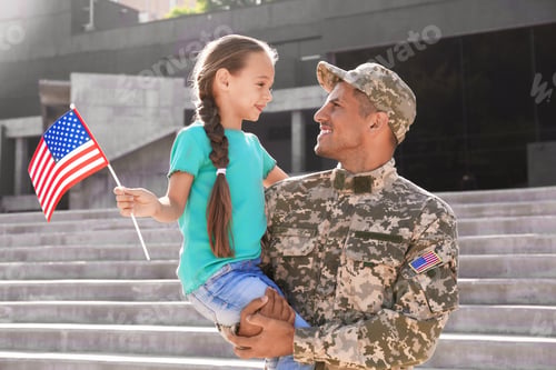 Preview: Soldier and his little daughter with American flag outdoors. Veterans Day in USA
