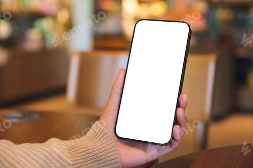 Preview: Mockup image of a woman holding and using mobile phone with blank desktop screen in cafe