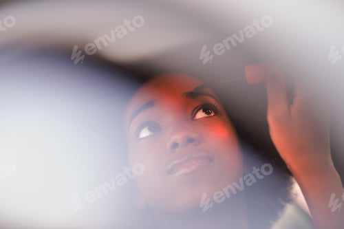 Preview: a young African-American woman makeup in the car