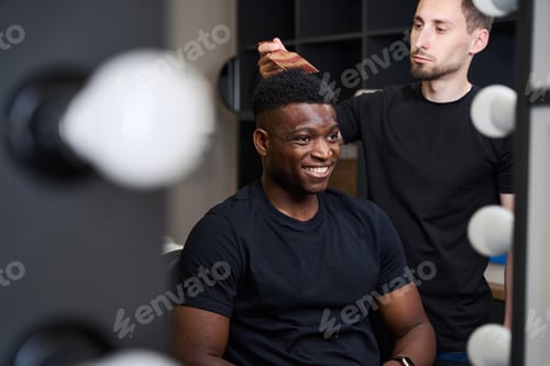 Preview: Stylist in front of mirror sets African American clients hair