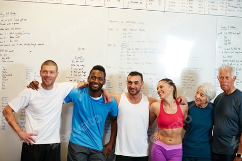 Preview: Cropped portrait of a group of people standing with their arms around one another in the gym