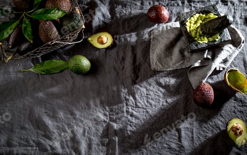 Preview: Avocado. Guacamole. Mexican guacamole sauce in stone mortar, full basket with avocado, half of